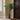 180cm tall artificial palm tree in a pot placed in the entrance corner, next to a door mat, creating a natural welcoming atmosphere