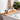 Bathtub caddy on a white bathtub holding fruits, aromatherapy, and skincare products, creating a relaxing bathing experience
