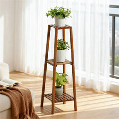 Double-tier plant stand with three supports against a light blue balcony wall, each tier holding a potted plant, surrounded by several smaller pots, creating a fresh and natural vibe