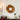 Autumn wreath adorned with maple leaves and small pumpkins hanging on the wall, with decorative items on the table nearby, creating a festive Halloween atmosphere.