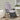 Black armchair with a light grey waterproof cushion on a white and brown striped outdoor rug